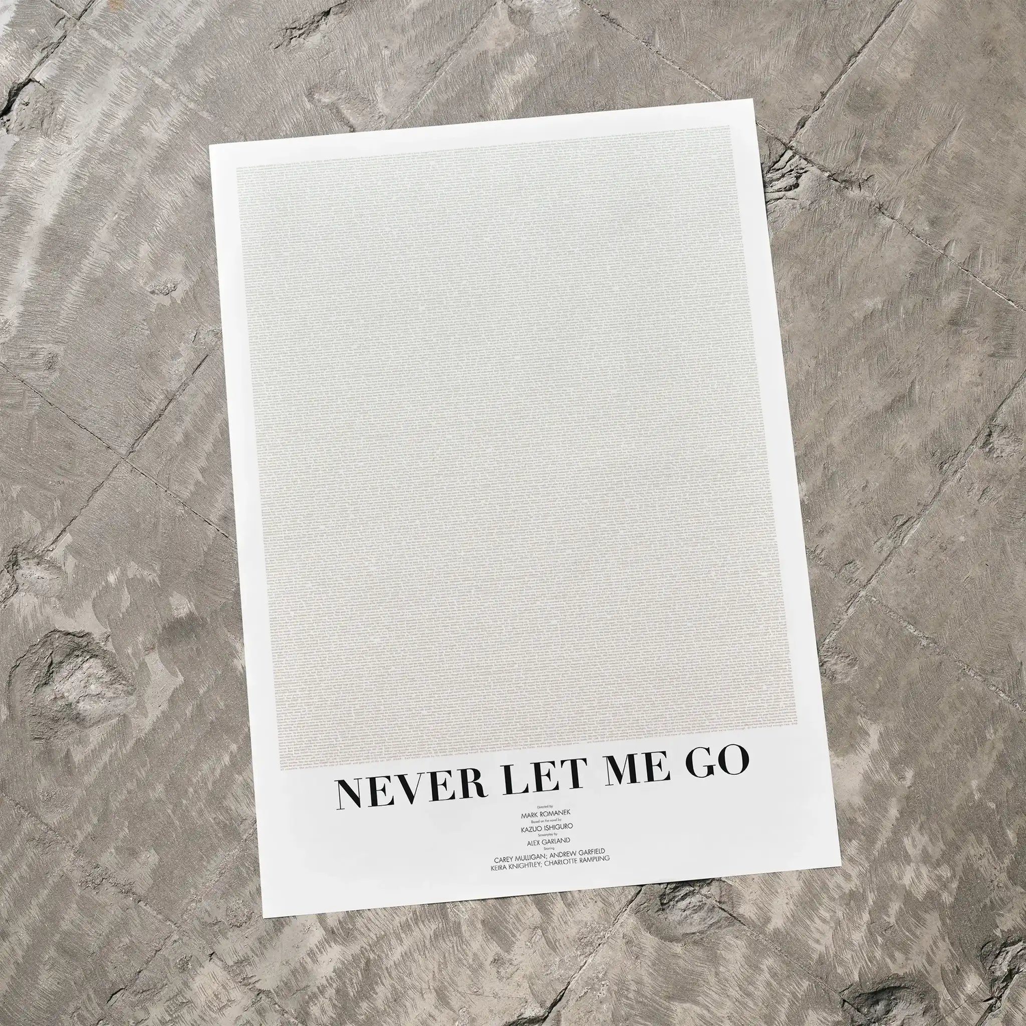 A Never Let Me Go movie script poster laid flat on a textured floor surface.