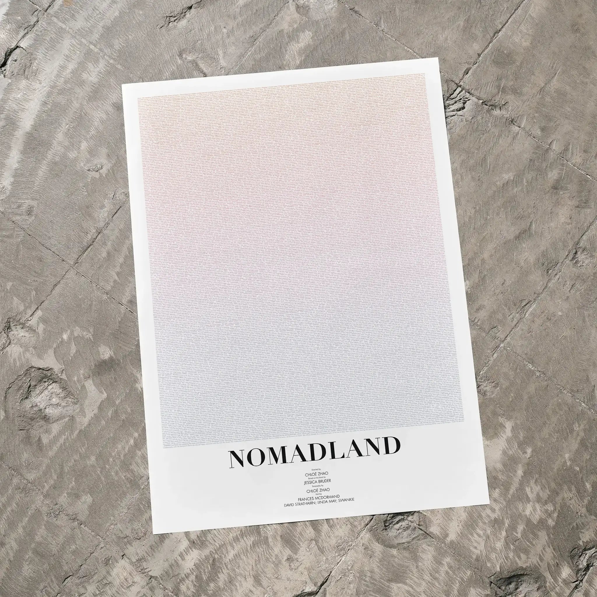 A Nomadland movie script poster laid flat on a textured floor surface.