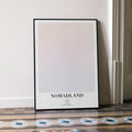 A framed Nomadland movie script poster leaning against a wall in a minimalist interior.
