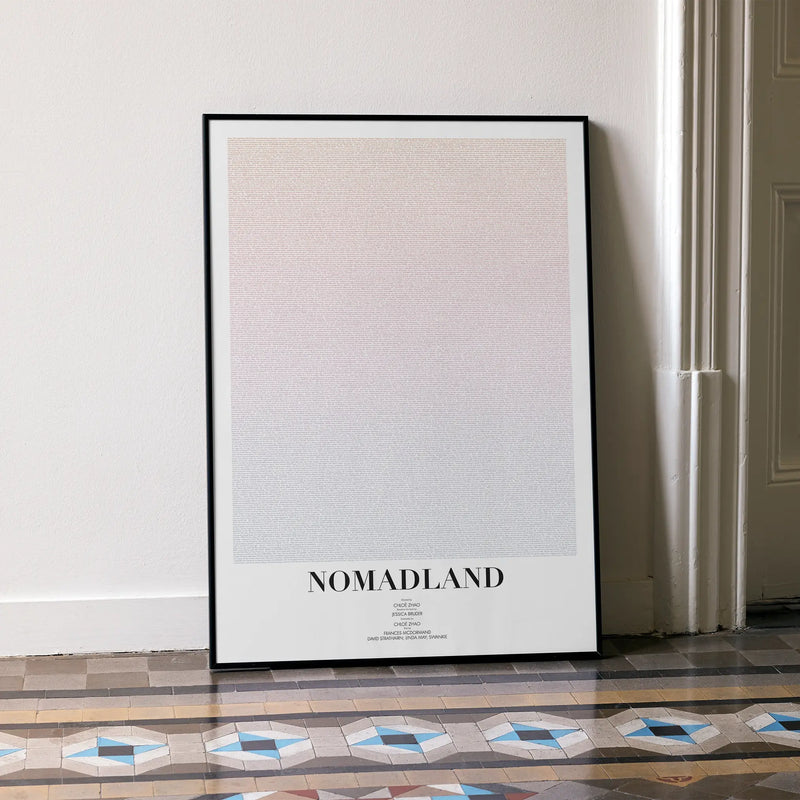 A framed Nomadland movie script poster leaning against a wall in a minimalist interior.