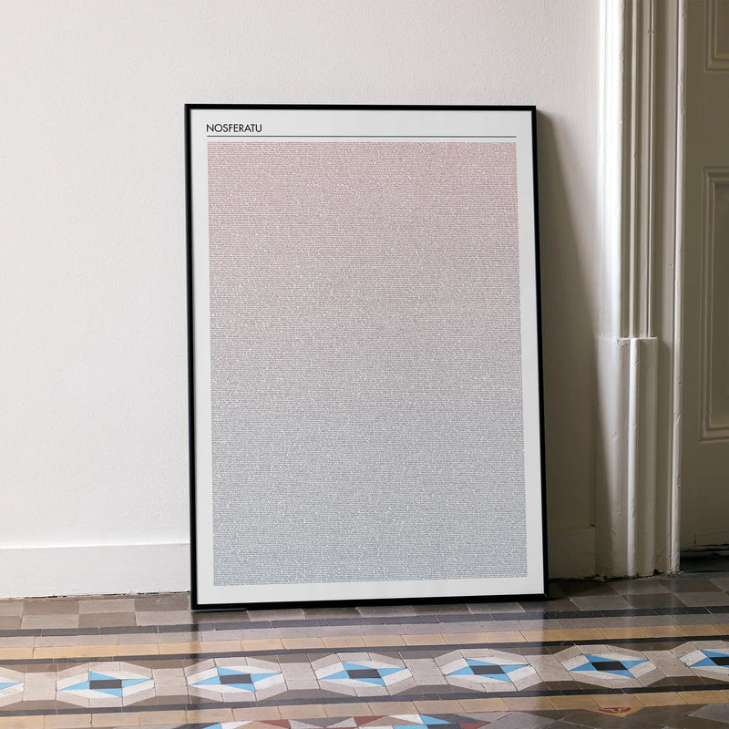 A framed Nosferatu movie script poster leaning against a wall in a minimalist interior.