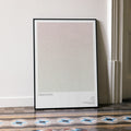 Framed poster titled 'Obsession' on a wall with decorative floor tiles.
