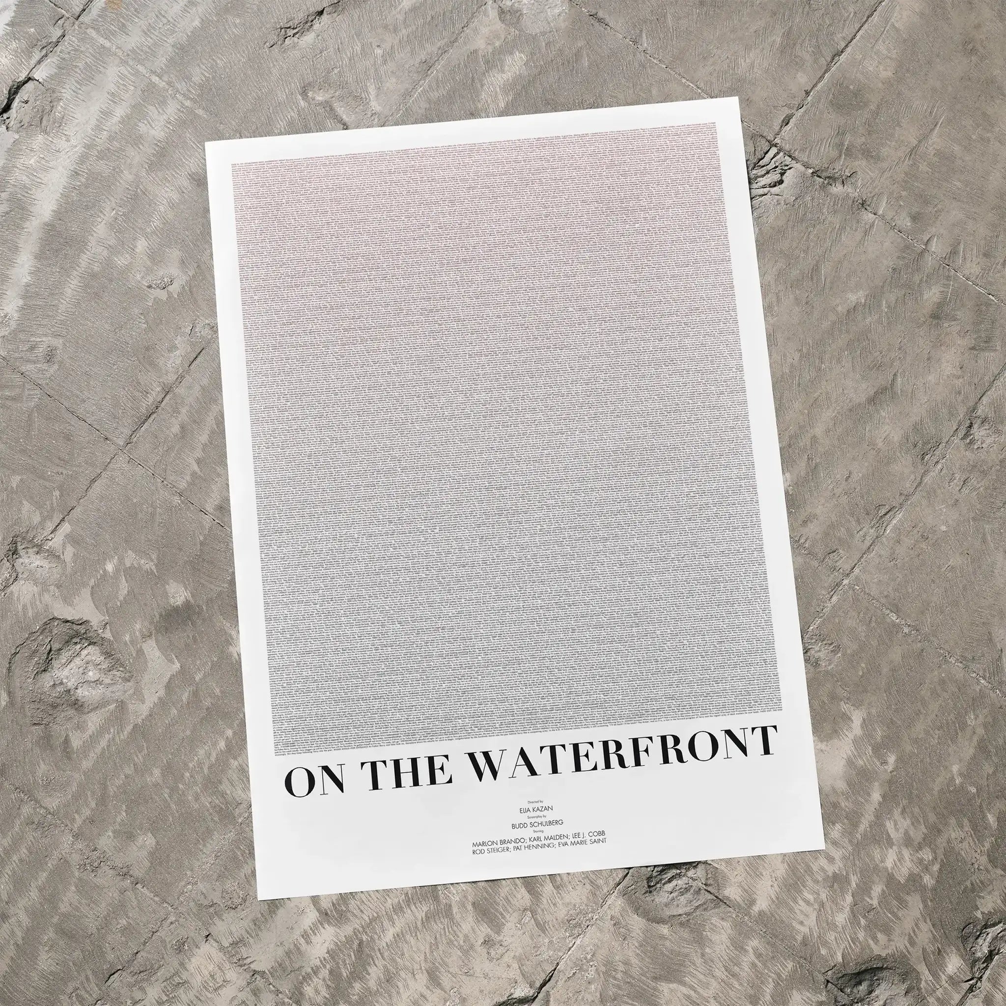 A On the Waterfront movie script poster laid flat on a textured floor surface.