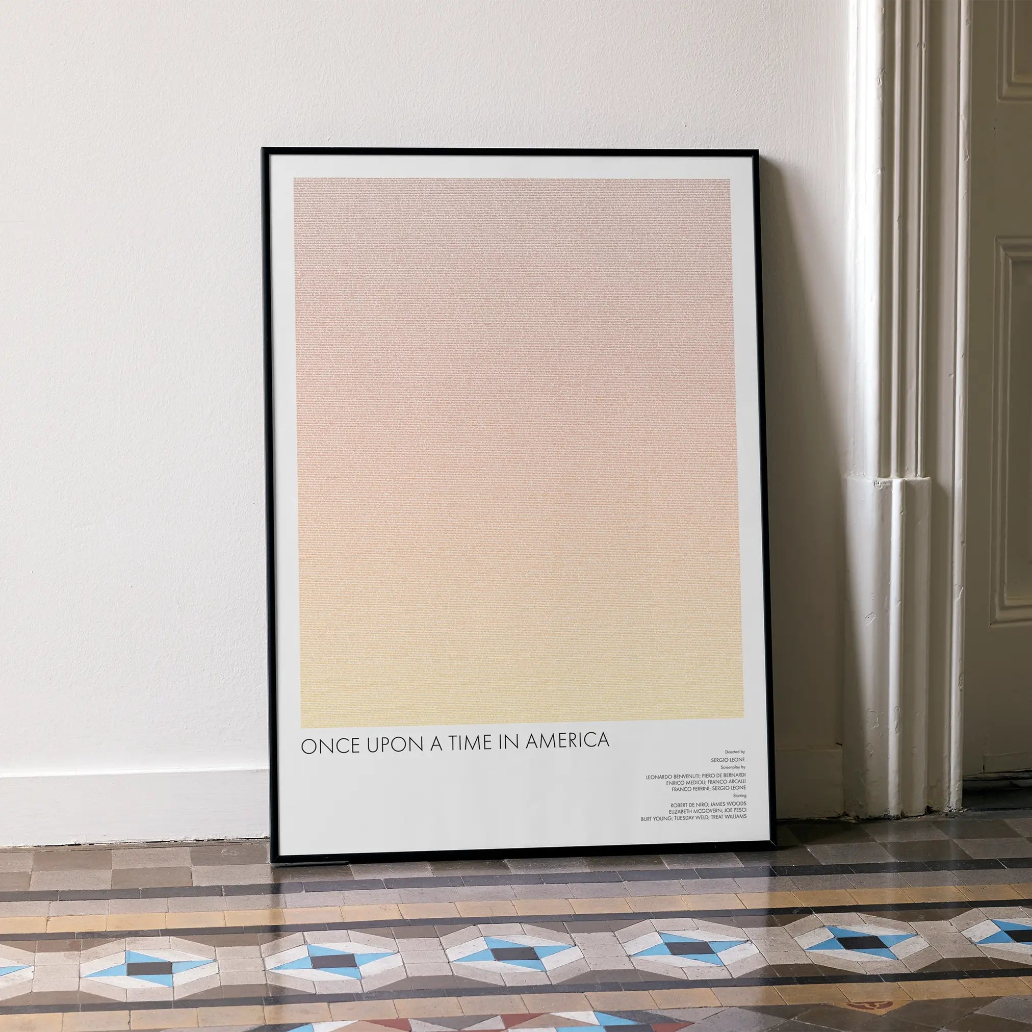 A framed Once Upon a Time in America movie script poster leaning against a wall in a minimalist interior.