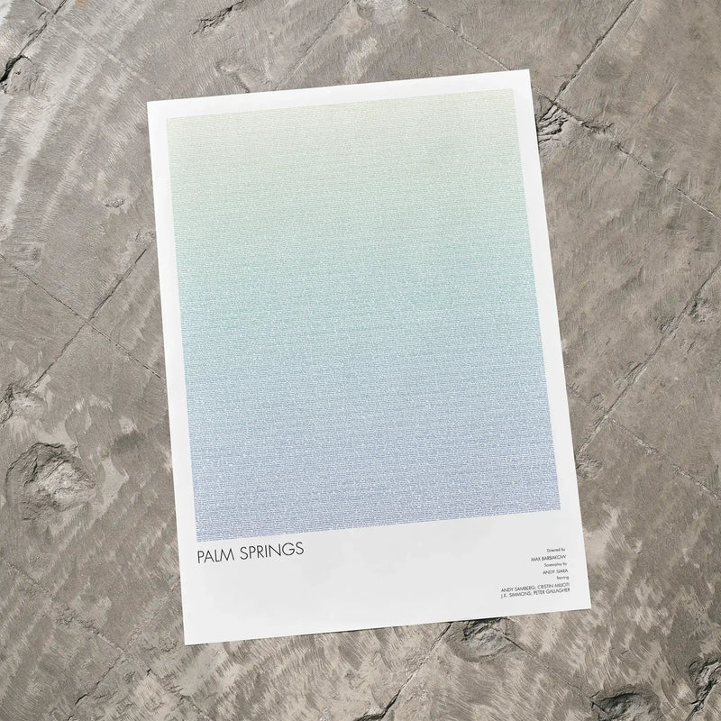 A Palm Springs movie script poster laid flat on a textured floor surface.