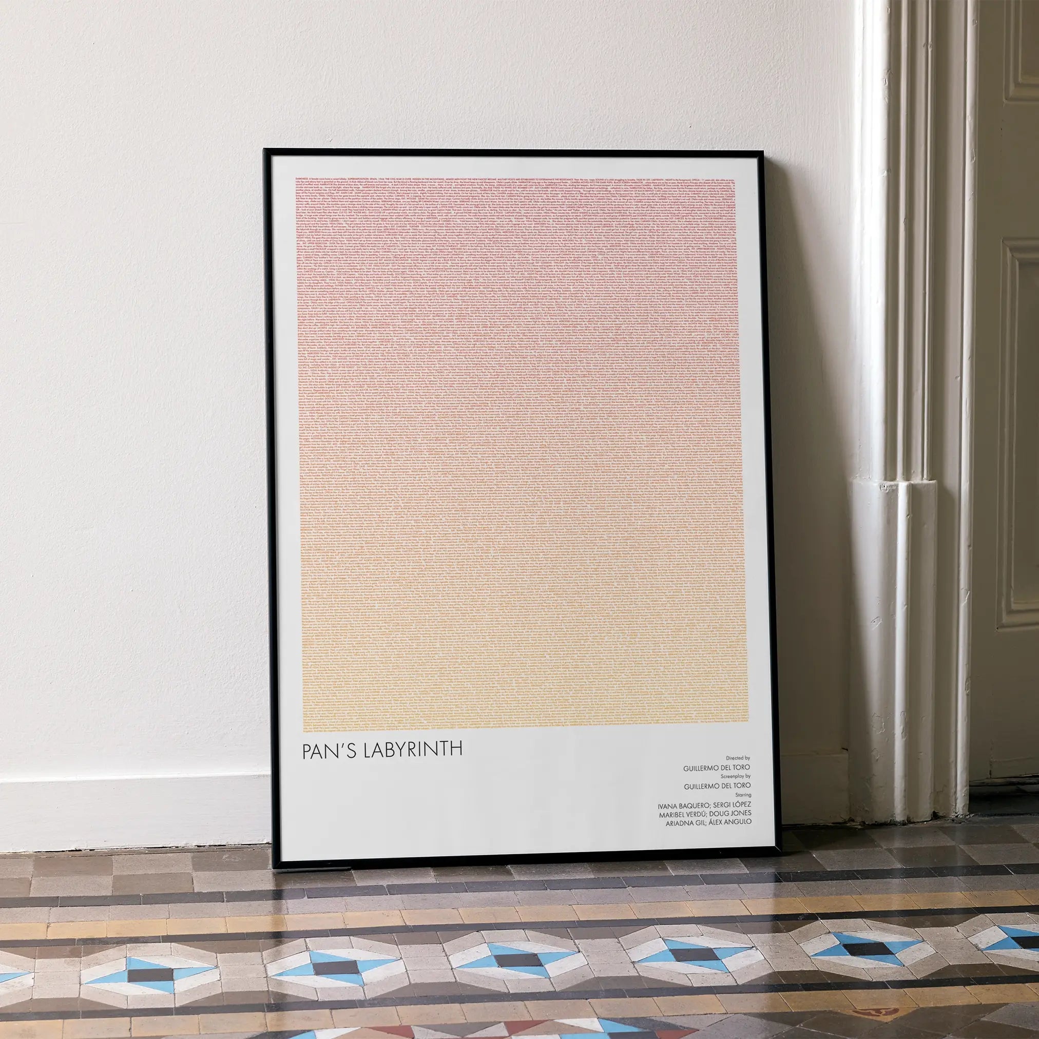 A framed Pan's Labyrinth movie script poster leaning against a wall in a minimalist interior.