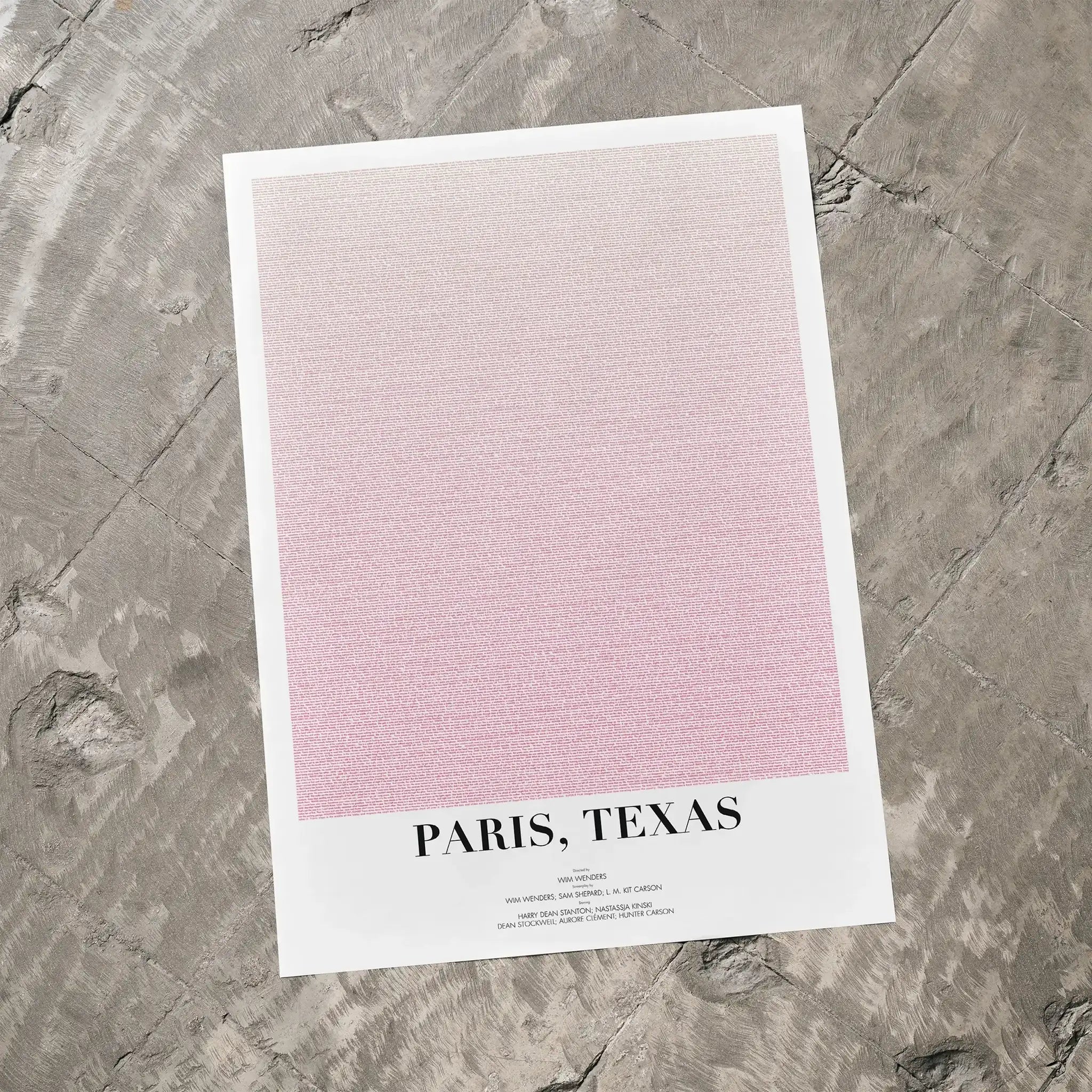 A Paris, Texas movie script poster laid flat on a textured floor surface.