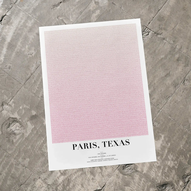 A Paris, Texas movie script poster laid flat on a textured floor surface.