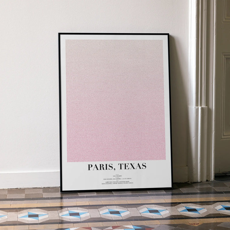 A framed Paris, Texas movie script poster leaning against a wall in a minimalist interior.