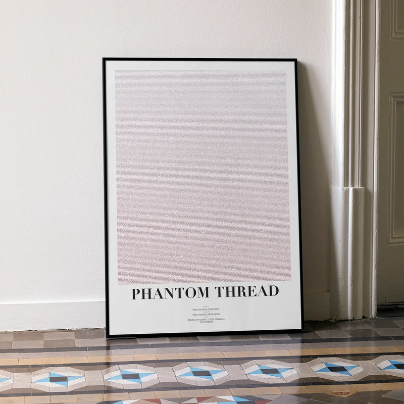 A framed Phantom Thread movie script poster leaning against a wall in a minimalist interior.