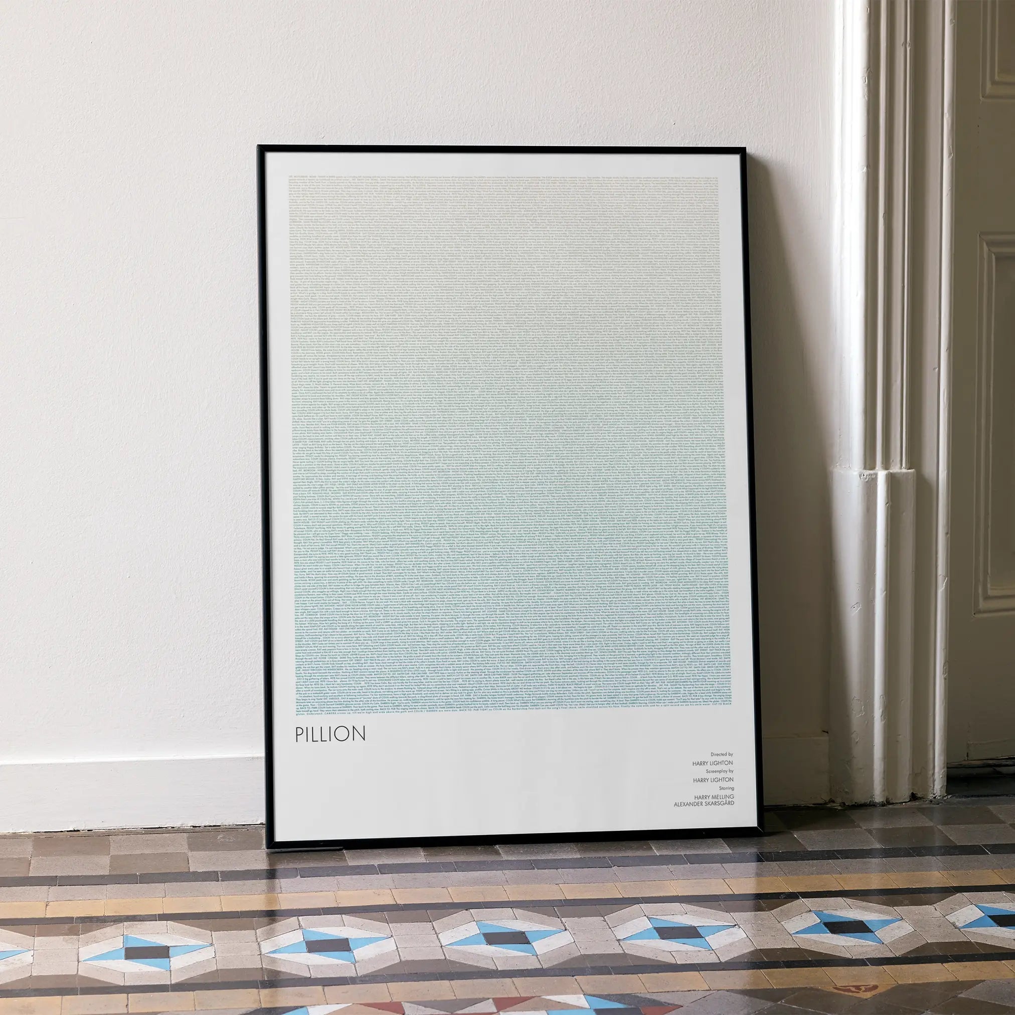 Framed poster for the film Pillion on a wall in a room with patterned floor