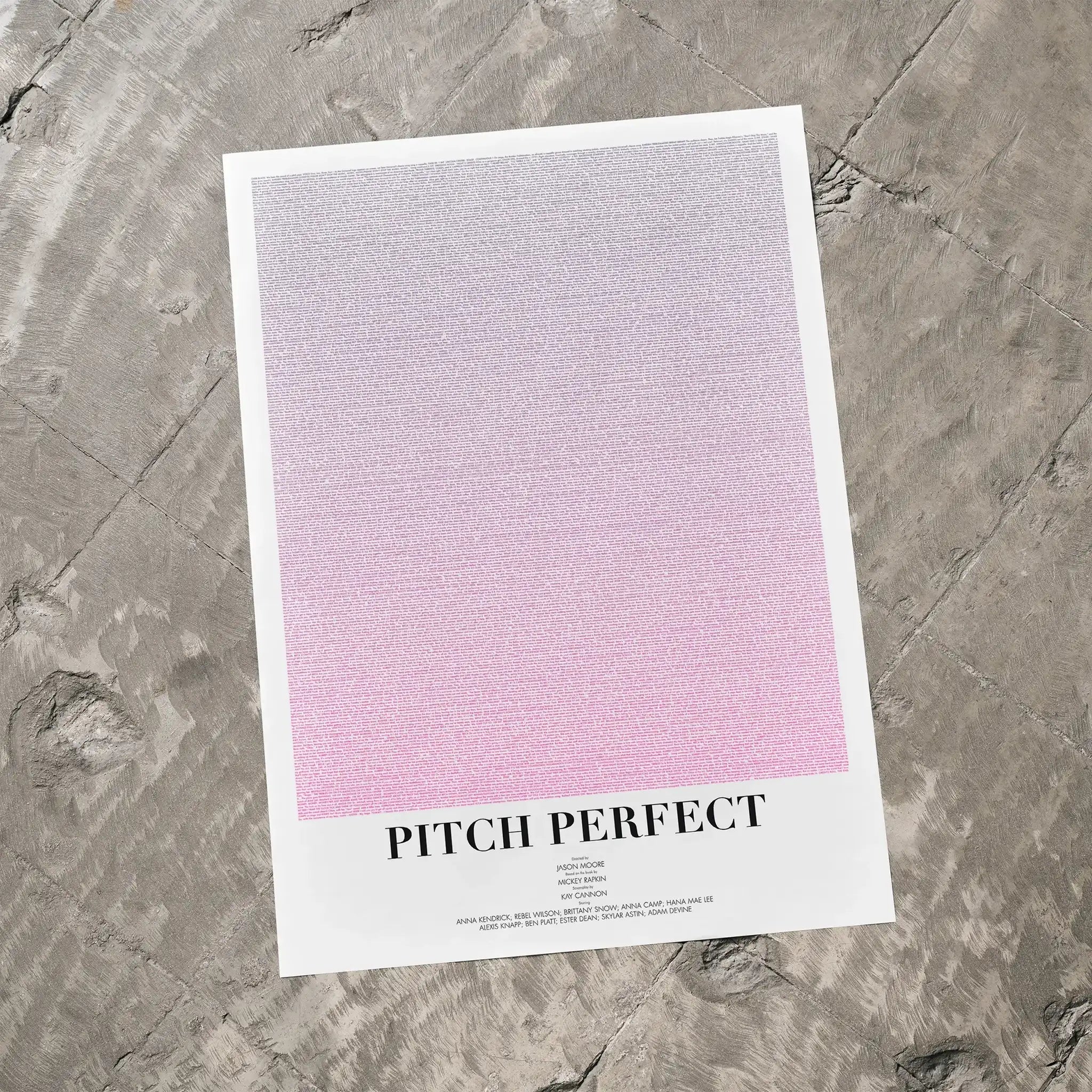 A Pitch Perfect movie script poster laid flat on a textured floor surface.