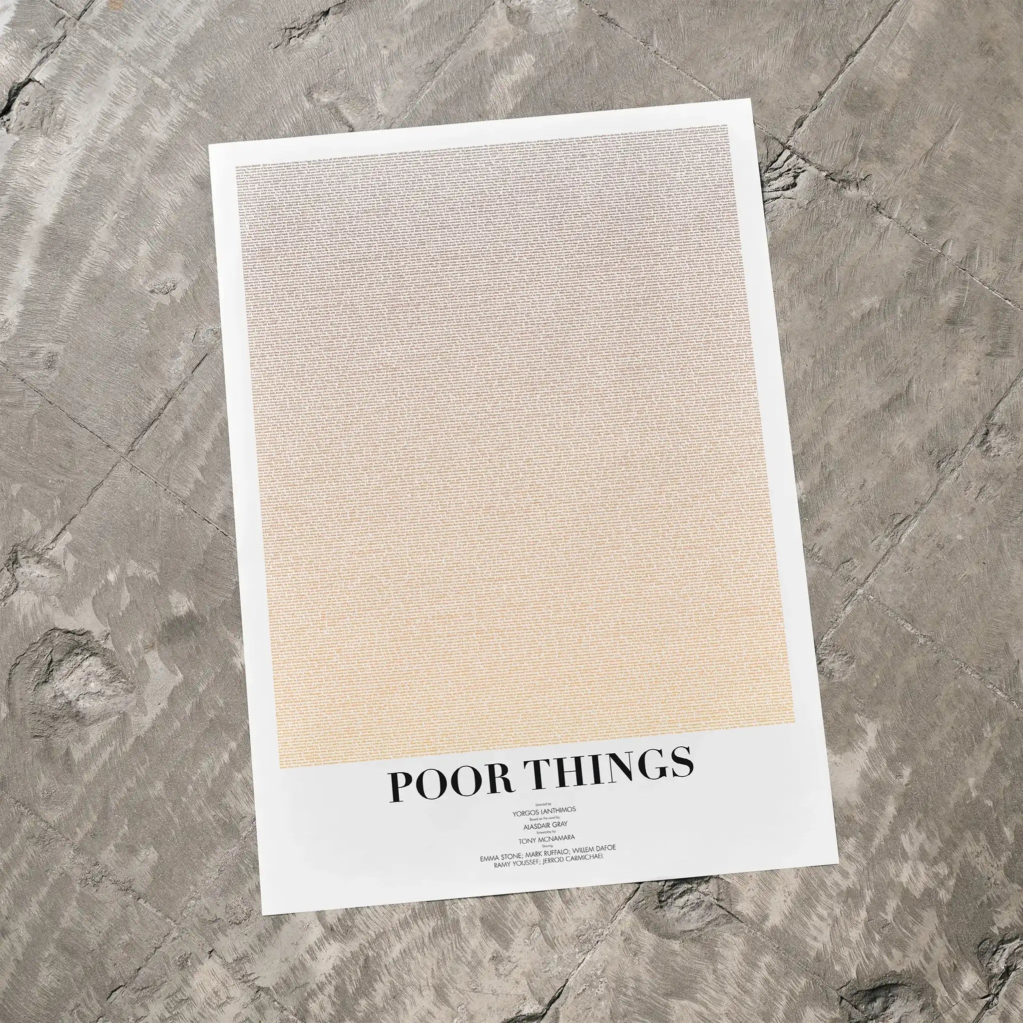 A Poor Things movie script poster laid flat on a textured floor surface.