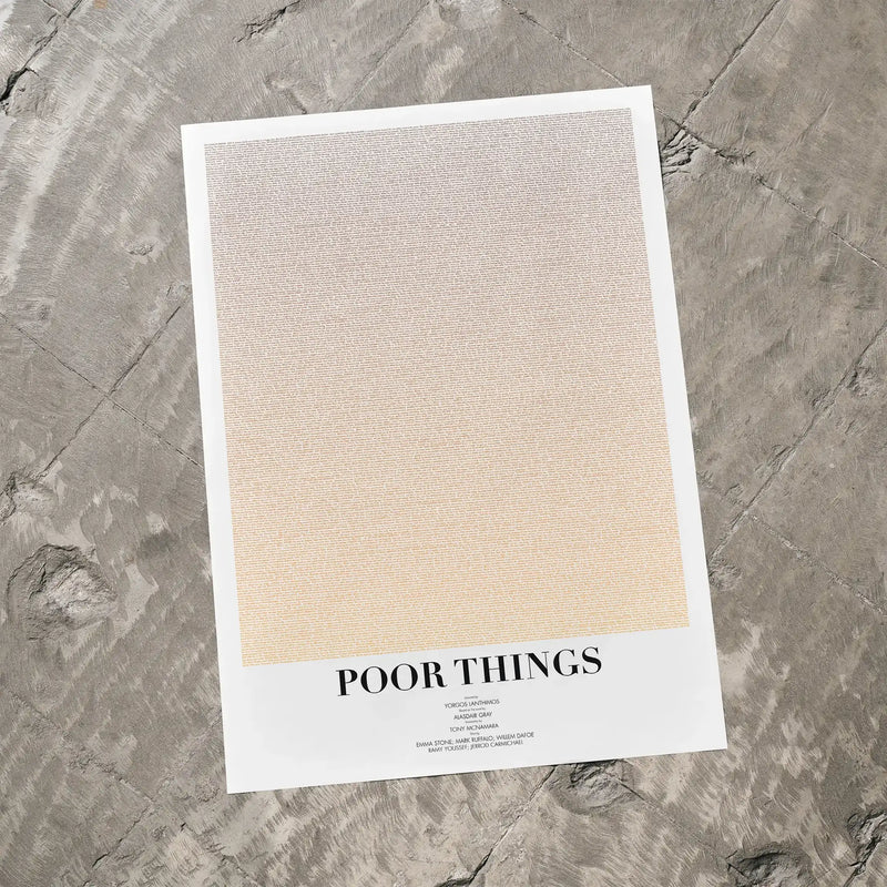 A Poor Things movie script poster laid flat on a textured floor surface.