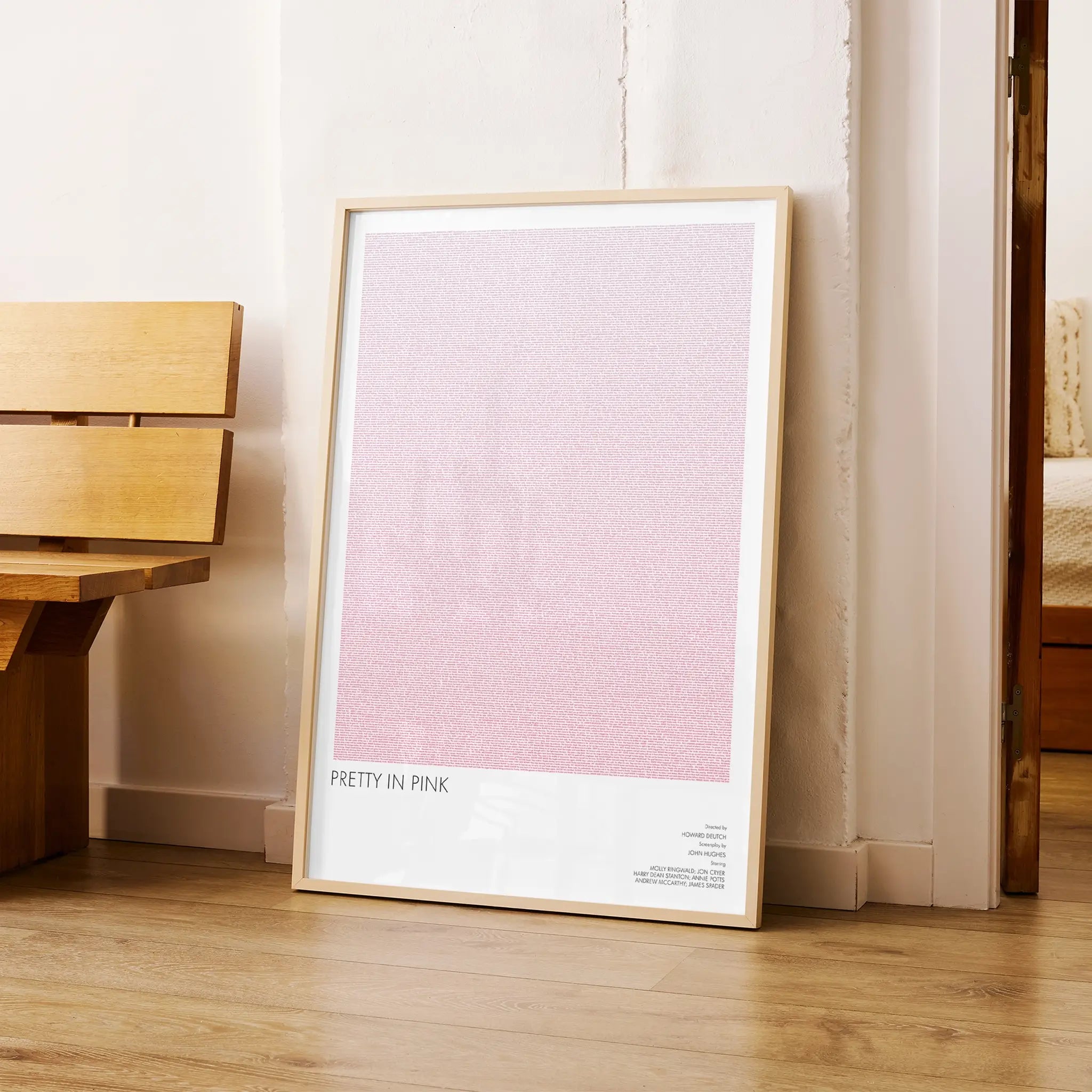 A framed Pretty in Pink movie script poster arranged in a minimalist interior setting.