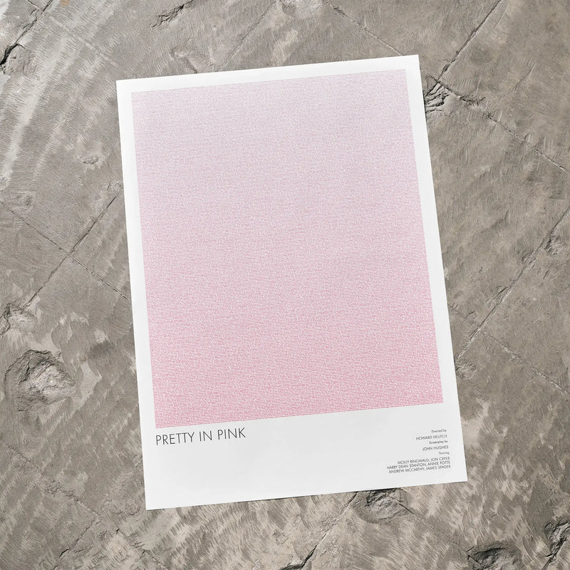 A Pretty in Pink movie script poster laid flat on a textured floor surface.