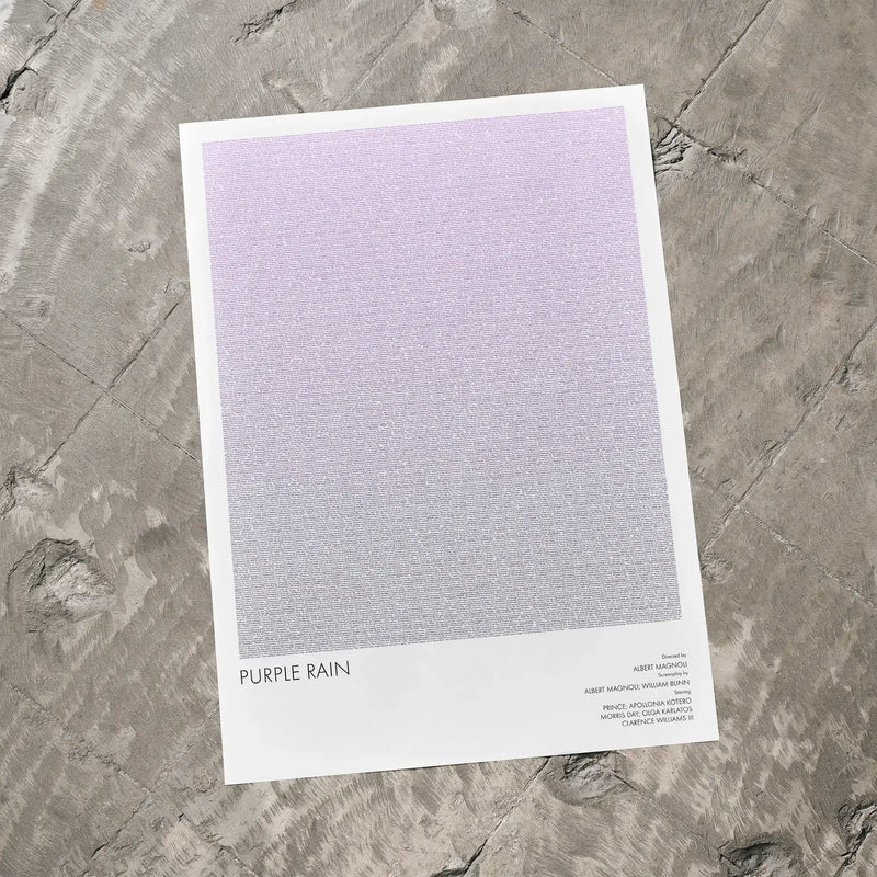 A Purple Rain movie script poster laid flat on a textured floor surface.