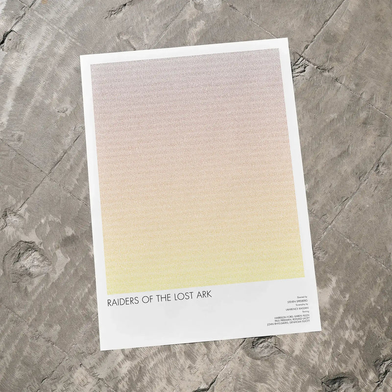 A Raiders of the Lost Ark movie script poster laid flat on a textured floor surface.