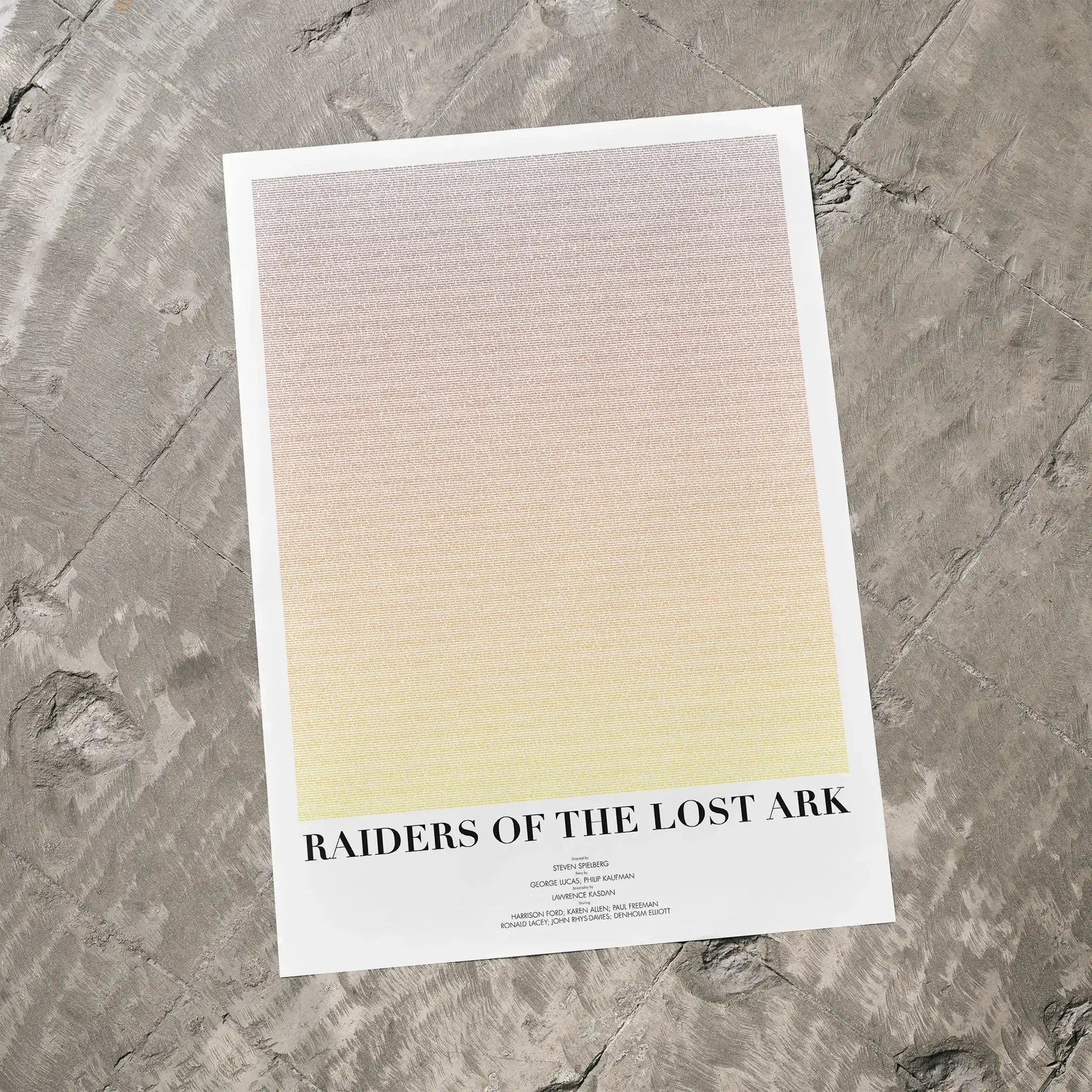 A Raiders of the Lost Ark movie script poster laid flat on a textured floor surface.