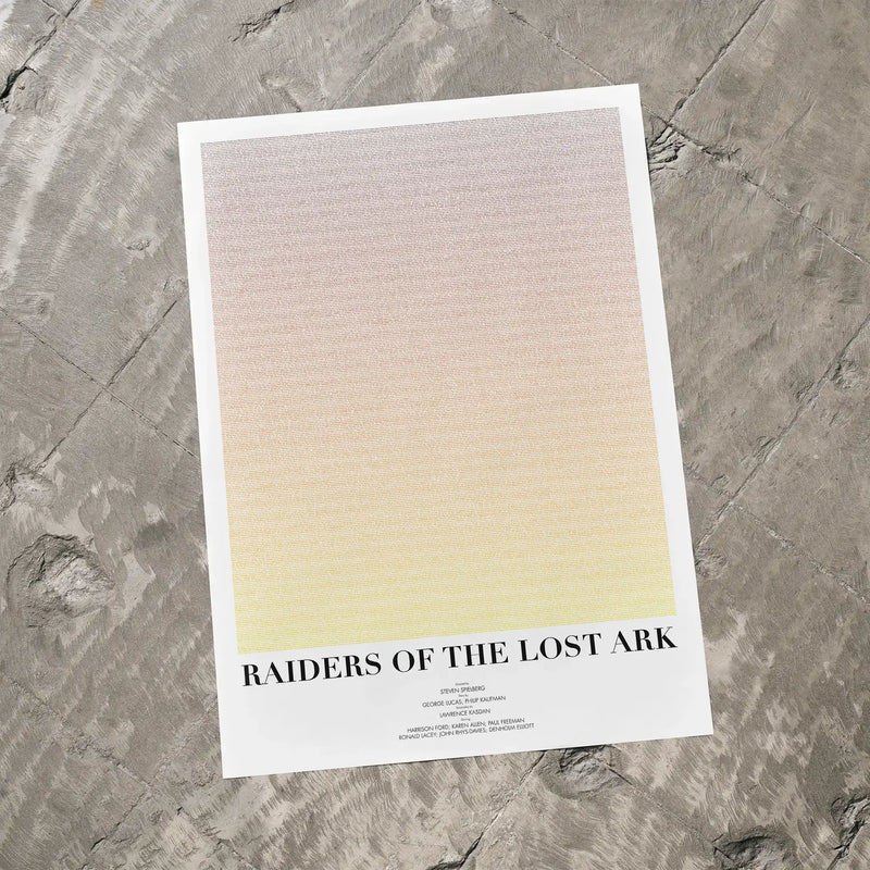 A Raiders of the Lost Ark movie script poster laid flat on a textured floor surface.