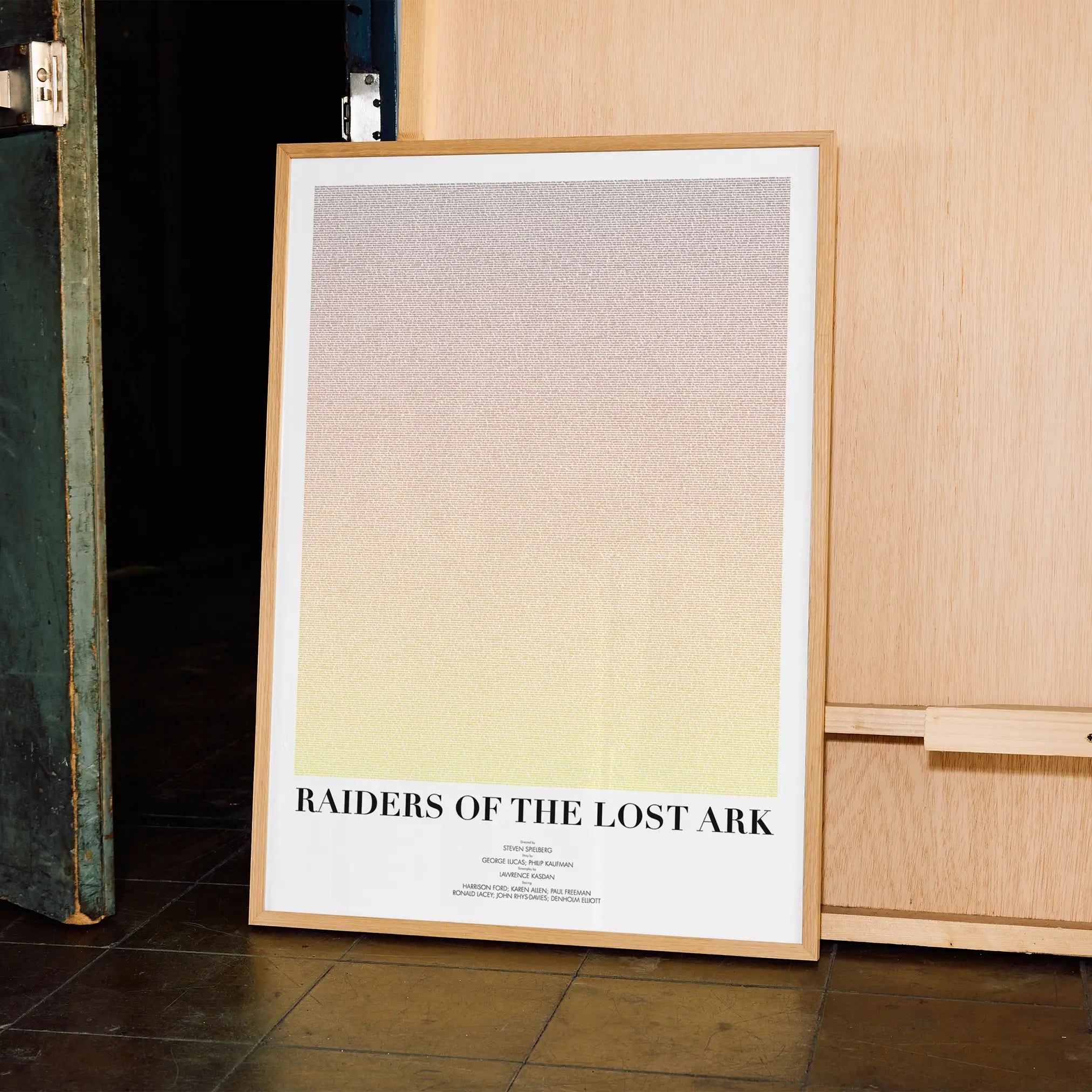 A framed Raiders of the Lost Ark movie script poster displayed in a contemporary interior setting.