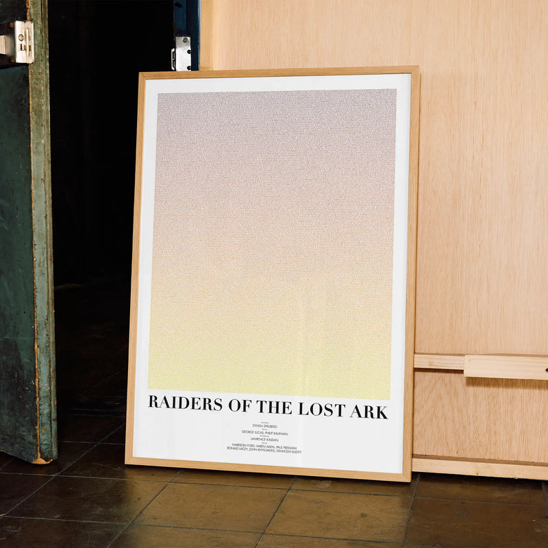 A framed Raiders of the Lost Ark movie script poster displayed in a contemporary interior setting.