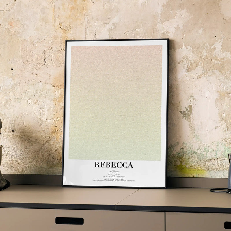 A framed poster for Hitchcock's "Rebecca" on a kitchen worktop.