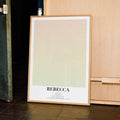 A framed poster for Hitchcock's "Rebecca" leaning against a wooden wall.