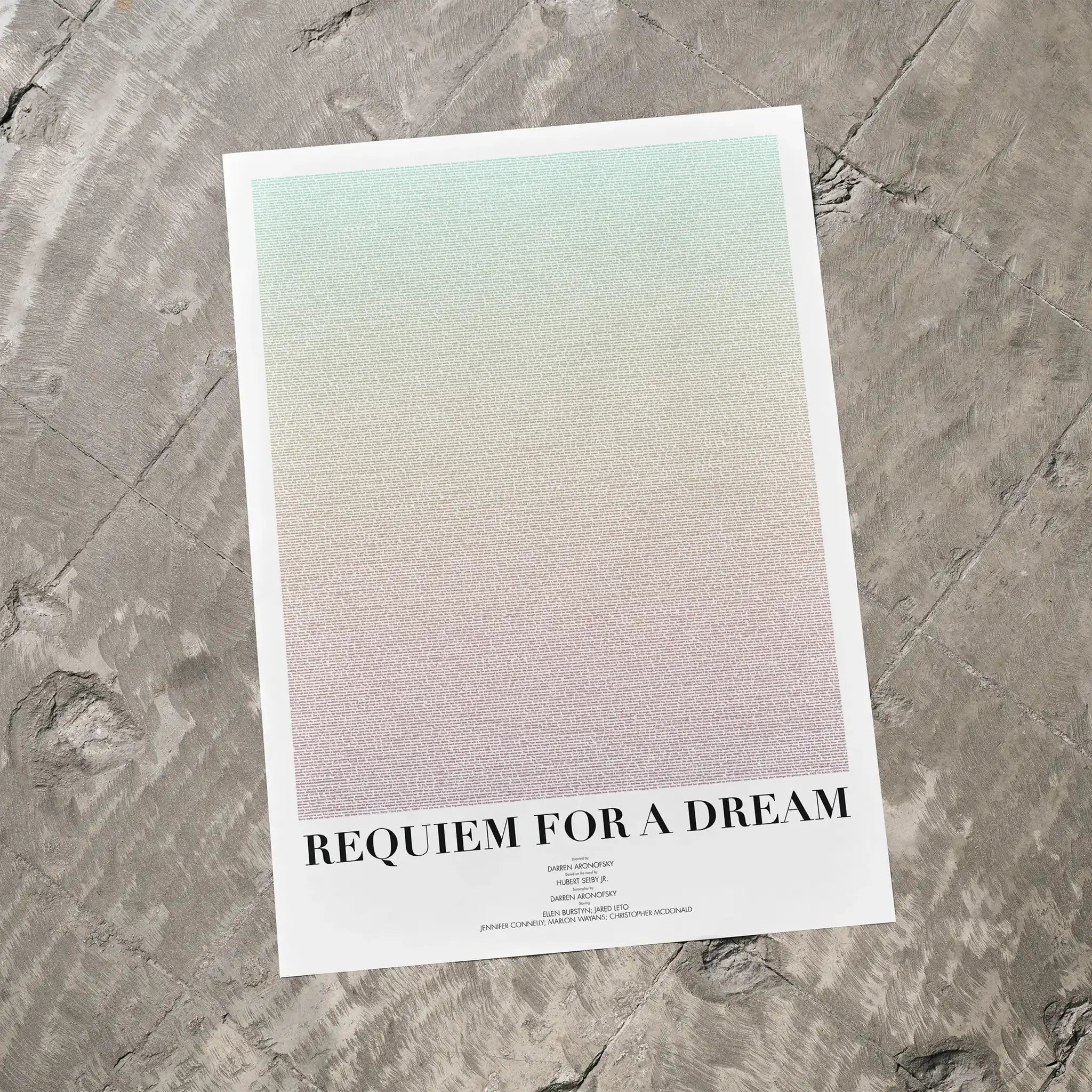 A Requiem for a Dream movie script poster laid flat on a textured floor surface.