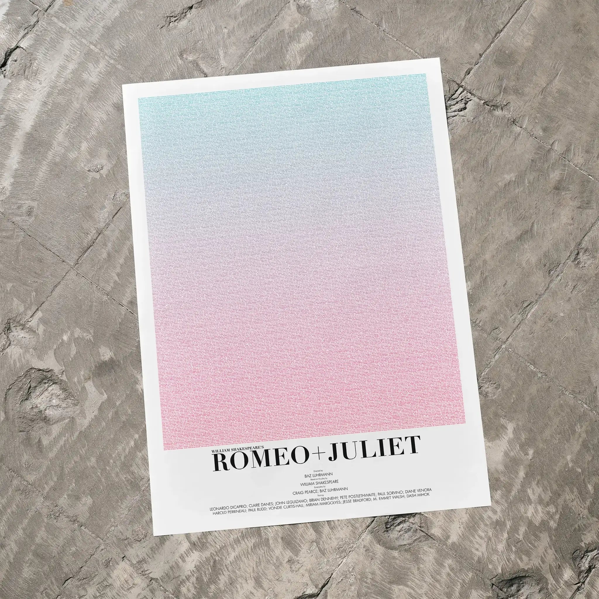 A Romeo + Juliet movie script poster laid flat on a textured floor surface.