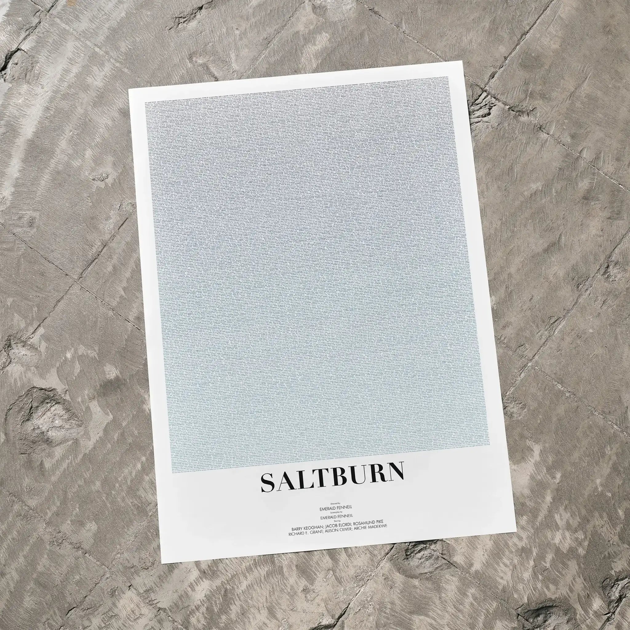 A Saltburn movie script poster laid flat on a textured floor surface.