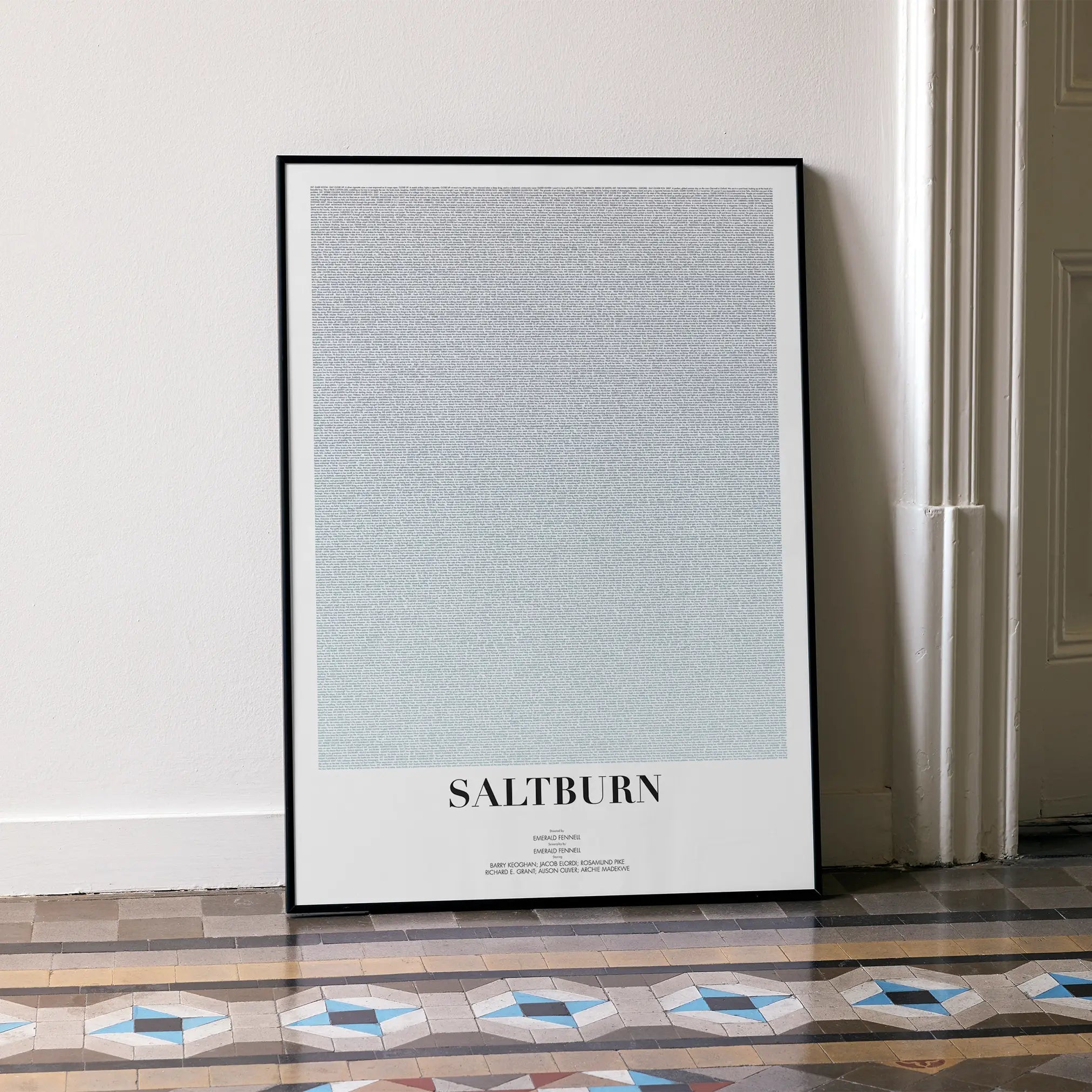 A framed Saltburn movie script poster leaning against a wall in a minimalist interior.