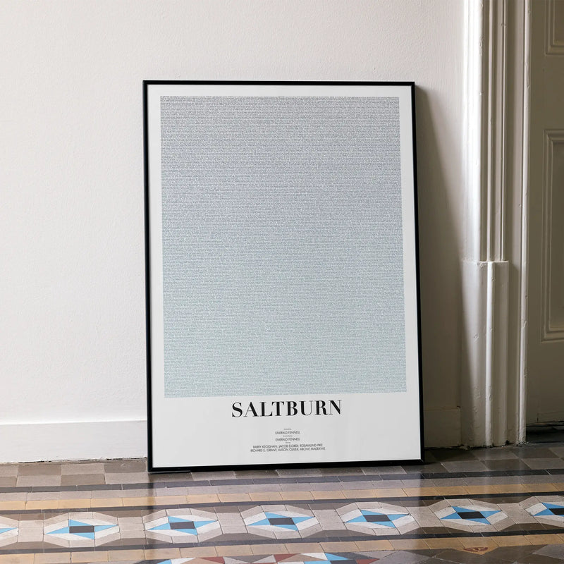 A framed Saltburn movie script poster leaning against a wall in a minimalist interior.
