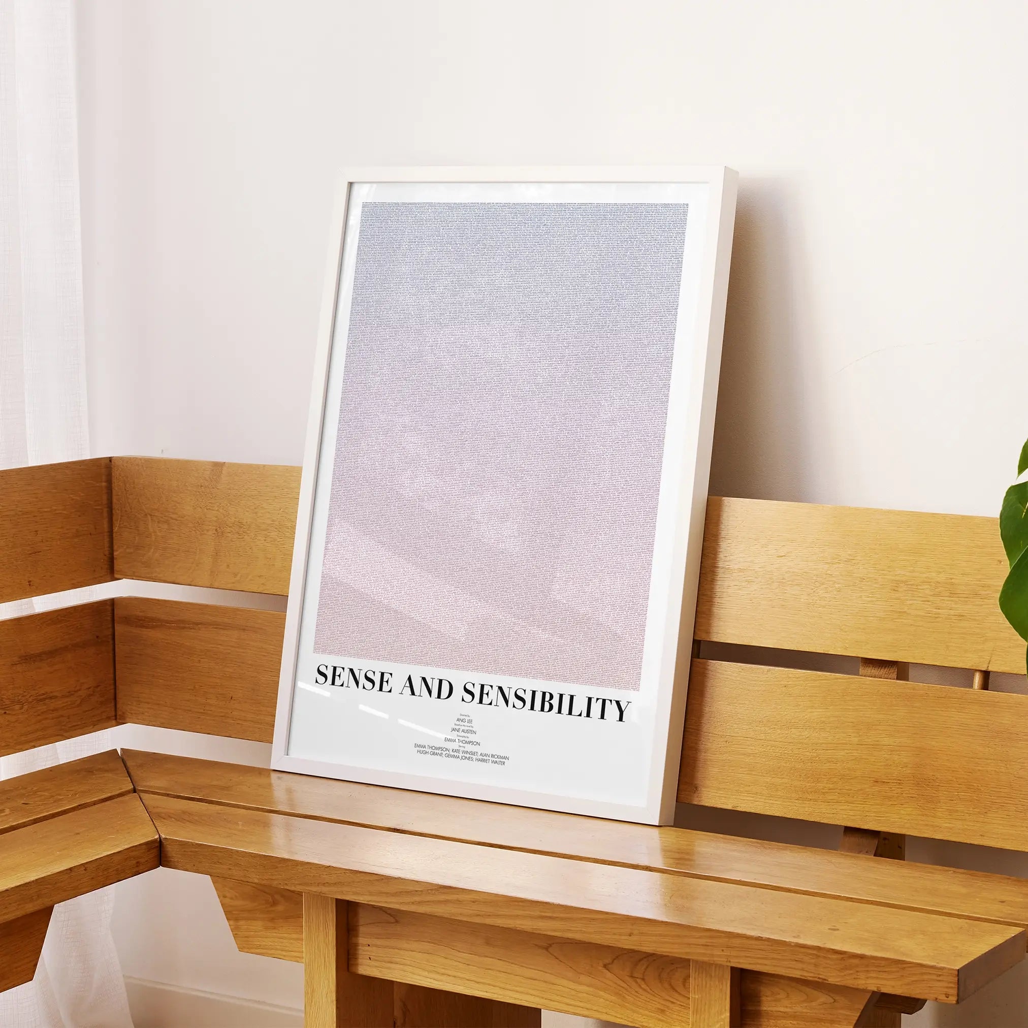 A framed Sense and Sensibility movie script poster displayed on a sideboard in a contemporary space.