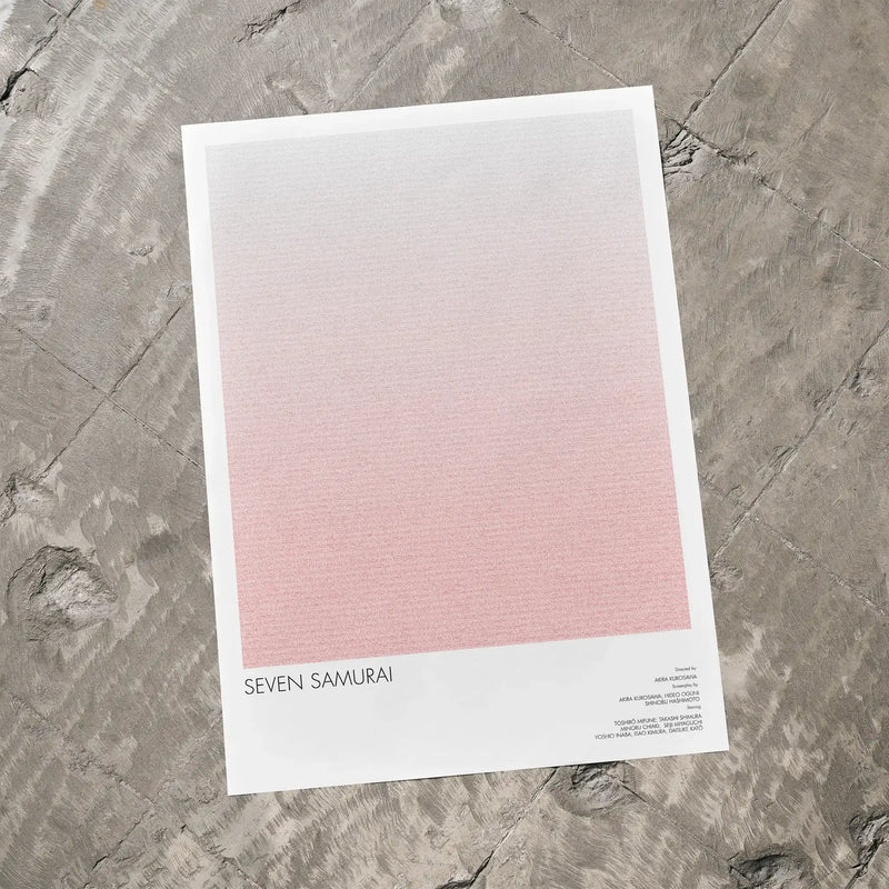 A Seven Samurai movie script poster laid flat on a textured floor surface.