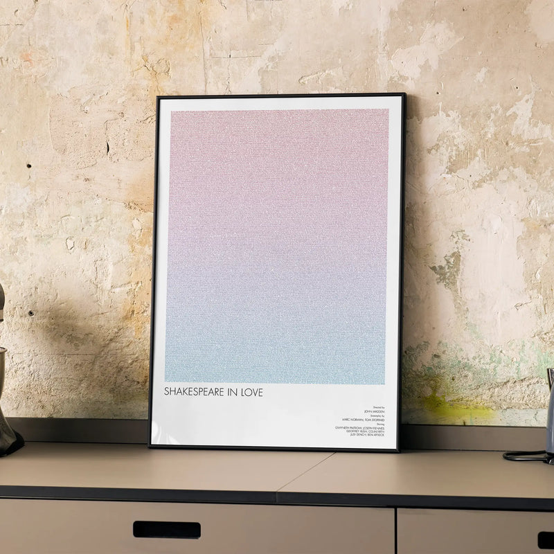 A framed Shakespeare in Love movie script poster displayed on a cabinet in a minimalist interior.