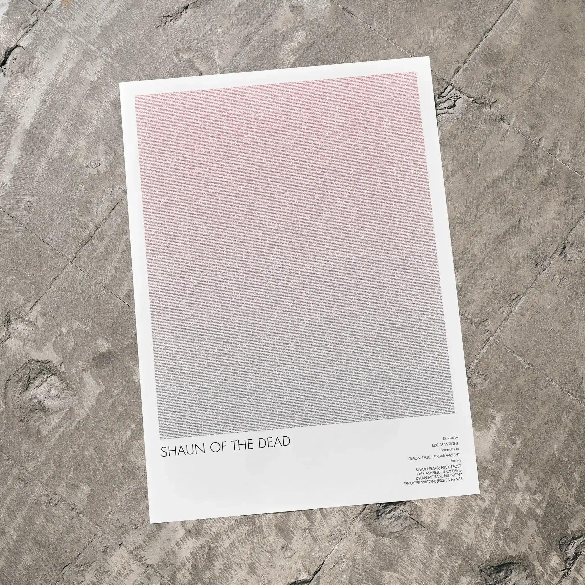 A Shaun of the Dead movie script poster laid flat on a textured floor surface.