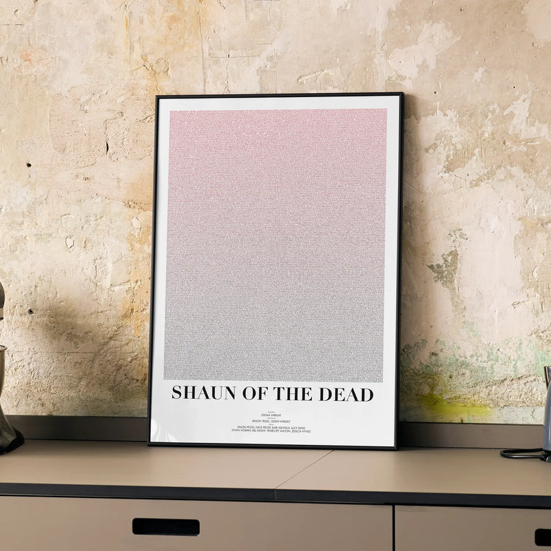 A framed Shaun of the Dead movie script poster displayed on a cabinet in a minimalist interior.