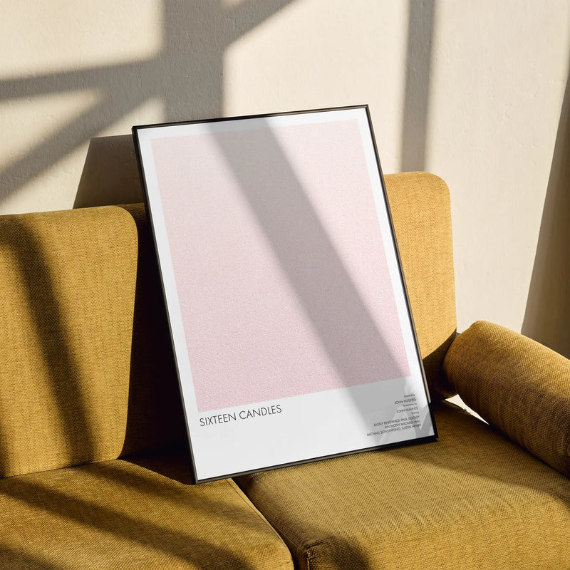 A framed Sixteen Candles movie script poster styled in a clean interior setting.