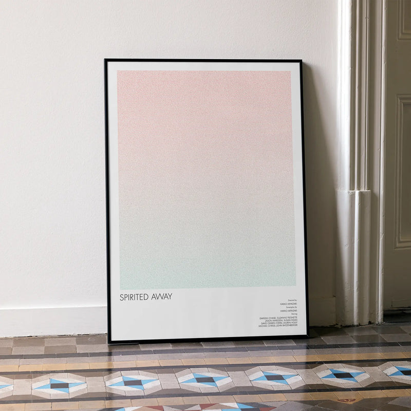 A framed Spirited Away movie script poster leaning against a wall in a minimalist interior.