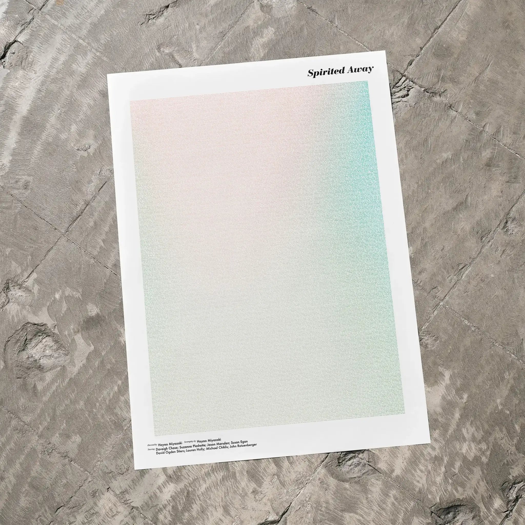 A Spirited Away movie script poster laid flat on a textured floor surface.