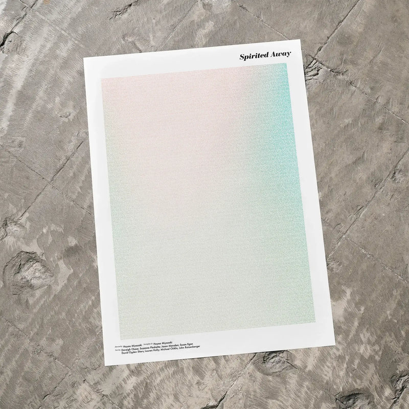 A Spirited Away movie script poster laid flat on a textured floor surface.