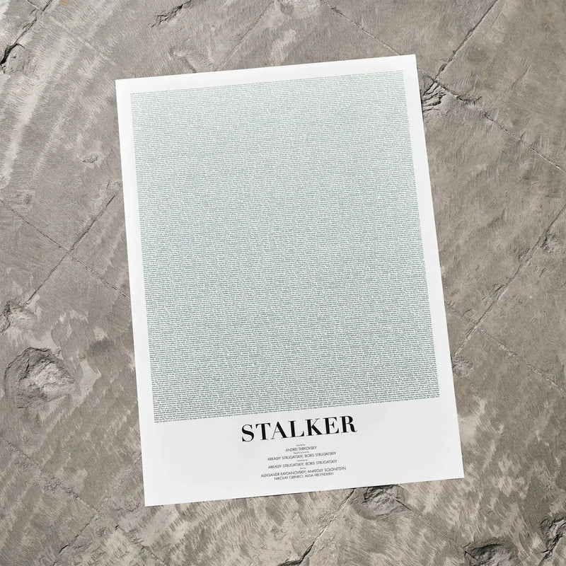 A Stalker movie script poster laid flat on a textured floor surface.