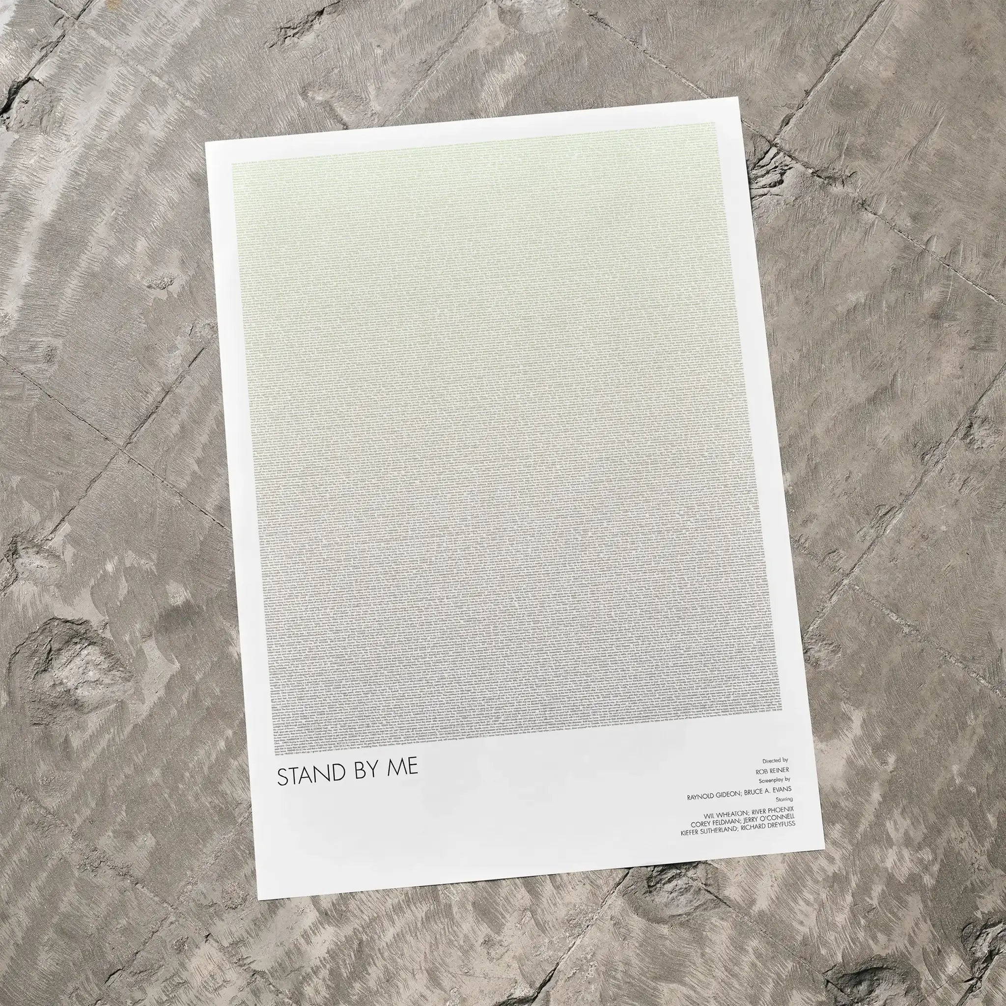 A Stand by Me movie script poster laid flat on a textured floor surface.