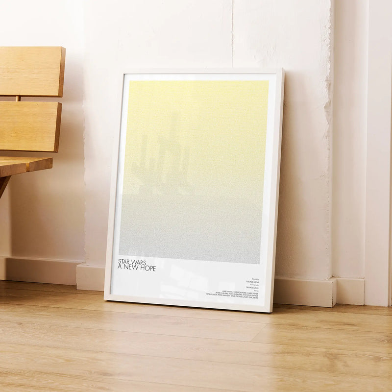 A framed Star Wars: A New Hope movie script poster leaning against a wall in a modern interior.