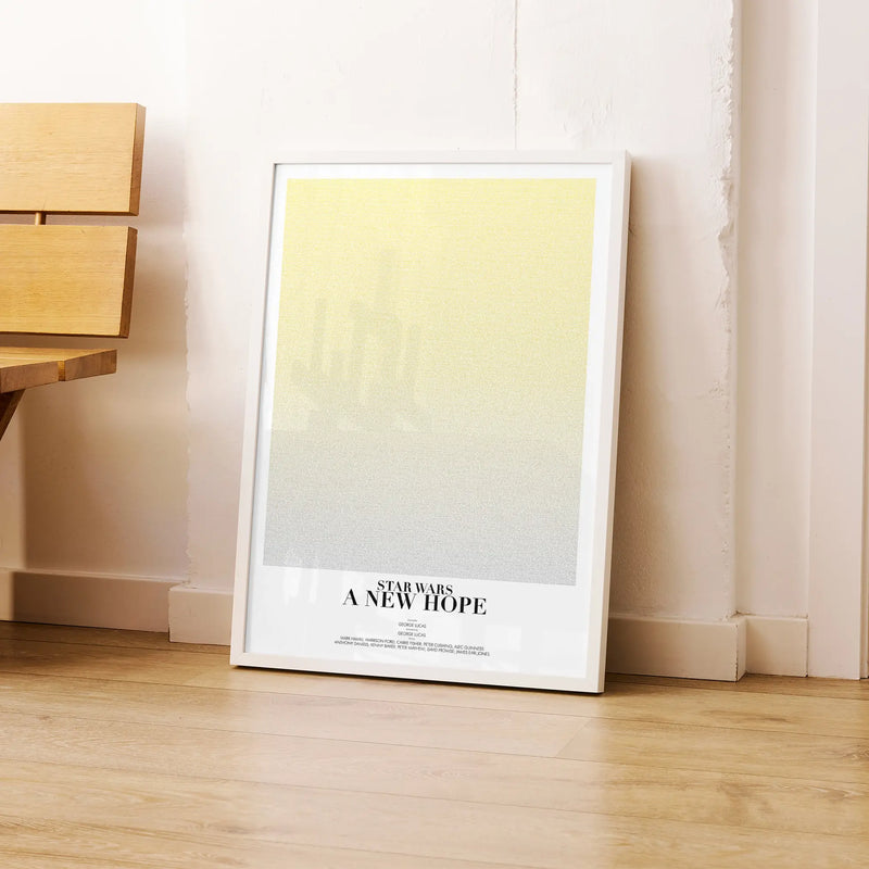 A framed Star Wars: A New Hope movie script poster leaning against a wall in a modern interior.