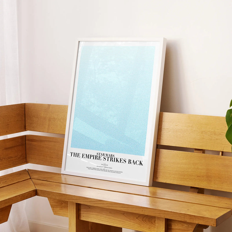 A framed Star Wars: The Empire Strikes Back movie script poster displayed on a sideboard in a contemporary space.