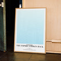 A framed Star Wars: The Empire Strikes Back movie script poster displayed in a contemporary interior setting.