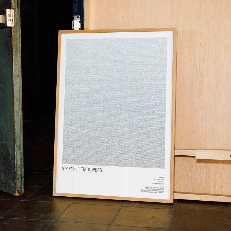 A framed Starship Troopers movie script poster displayed in a contemporary interior setting.