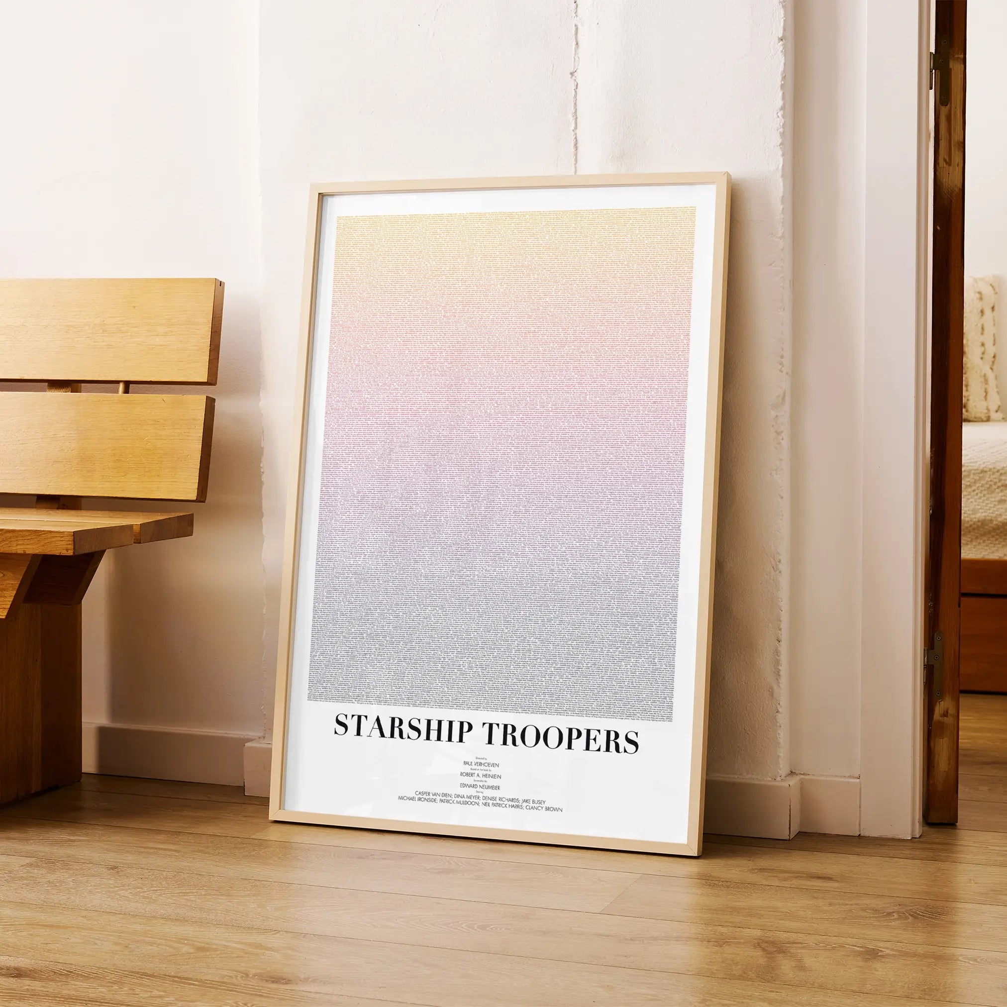 A framed Starship Troopers movie script poster arranged in a minimalist interior setting.